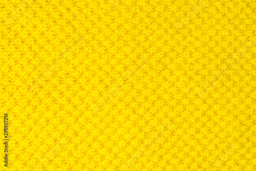 The tail is made of yellow knitted fabric texture. knitting texture close up Photo. orange, yellow knitted background. the texture of the warm fabric. colorful bright wool