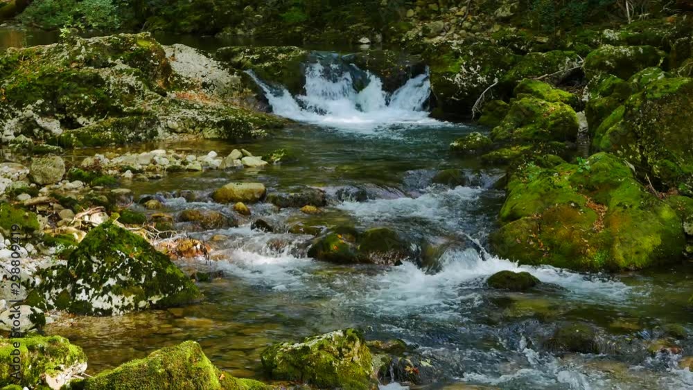 water stream flowing over mossy rocks full of small waterfalls and rapids camera moves slowly from up to down water stream flowing over mossy rocks full of small waterfalls and rapids camera moves slowly from up to down