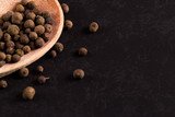 Black pepper peas in a wooden spoon scattered. Concept, copy space.