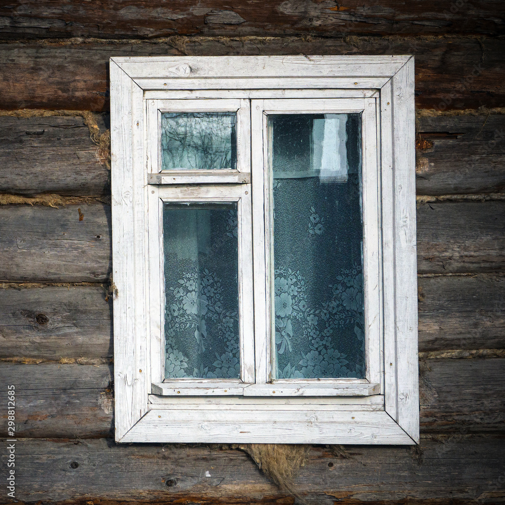 Old window in a country house. The texture of the logs. Rustic background Old window in a country house. The texture of the logs. Rustic background