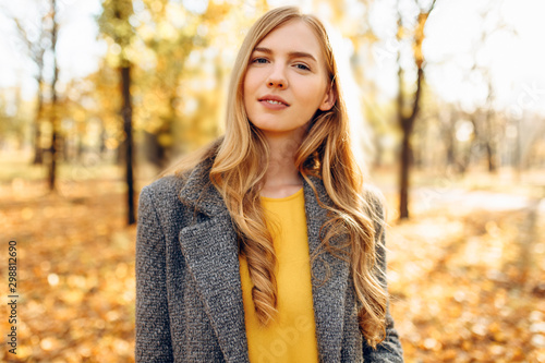 Beautiful young girl in Park on a background of yellow autumn leaves