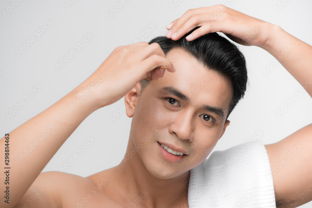 beauty, grooming and people concept - smiling young man brushing hair with comb over white background beauty, grooming and people concept - smiling young man brushing hair with comb over white background