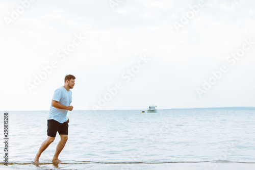 man running by sea beach barefoot © phpetrunina14