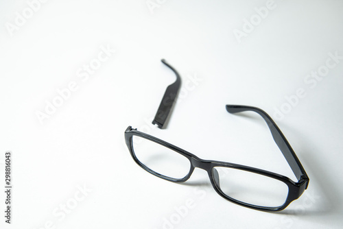Broken bow near glasses on white background