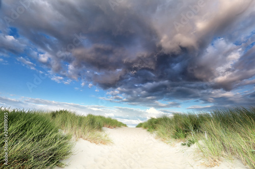 Fototapeta Naklejka Na Ścianę i Meble -  dramatic rain clouds over path up sand dune