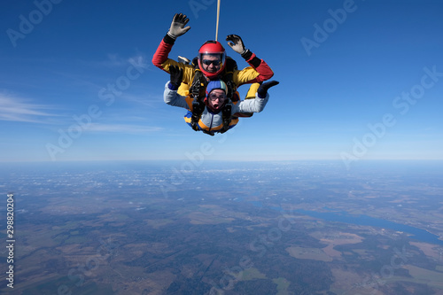 Skydiving. Tandem jump. A man and a woman are in the sky.