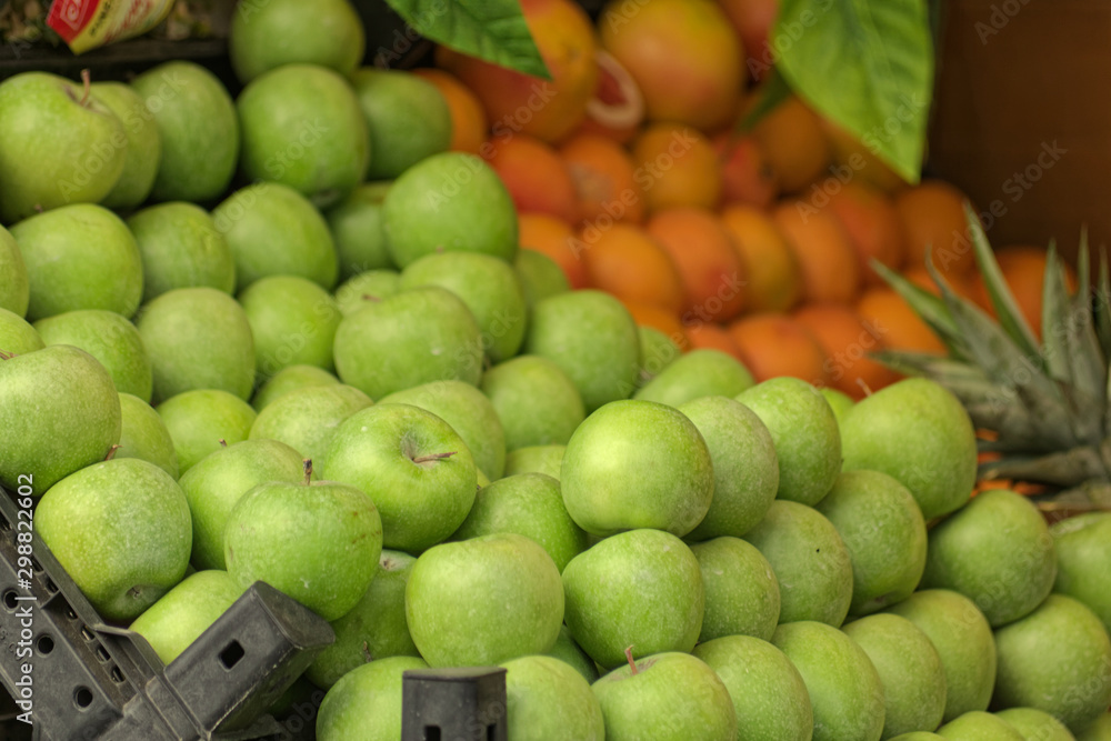 Perspective view of a Granny Smith Apples and on a street grocery counter in old town. Grapefruit also shown on a minor portion. Perspective view of a Granny Smith Apples and on a street grocery counter in old town. Grapefruit also shown on a minor portion.