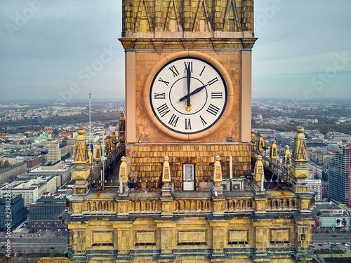 Beautiful panoramic aerial close-up drone view to the Millennium clock (clock face diameter = 6.5 m) on the tower of PKiN and cityscape of Warsaw modern City, Poland