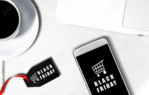 Mobile phone screen with Black Friday advert and label with Black Friday text on the desk