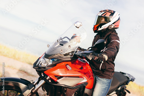 Woman on a motorbike looking at the ocean view. Adventure trip