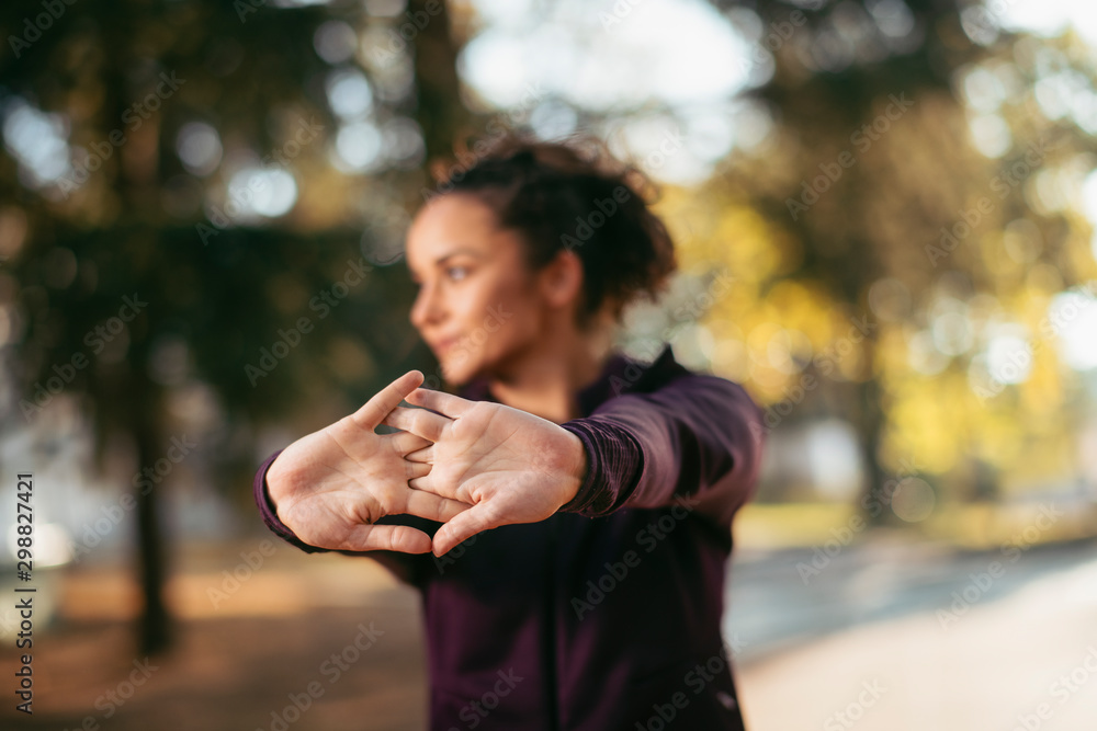 Portrait of sportswoman warming herself up for training. Beautiful woman in sportswear outdoors working out. Portrait of sportswoman warming herself up for training. Beautiful woman in sportswear outdoors working out.
