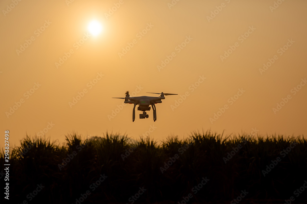 Silhouette drone against the background of the sunset. Flying drones in the  evening sky. UAV Drone