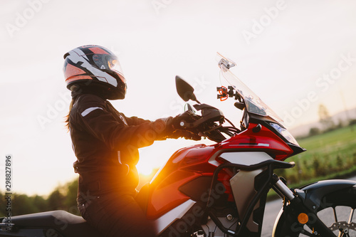 Billede på lærred Woman riding motobike at sunset