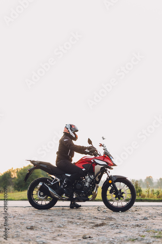 Woman standing on roadside with a motorbike. Motorcycle trip © Photocreo Bednarek