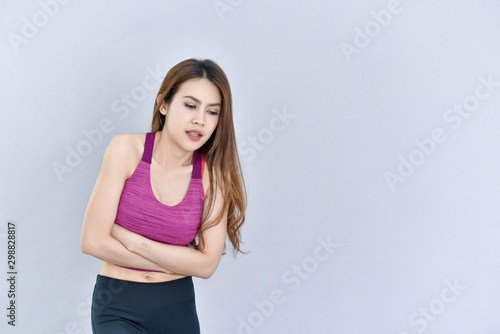 Beautiful girl Wear a fitness shirt. Above the separate white background and Hands on stomach because indigestion, painful pain, discomfort Pain concept
