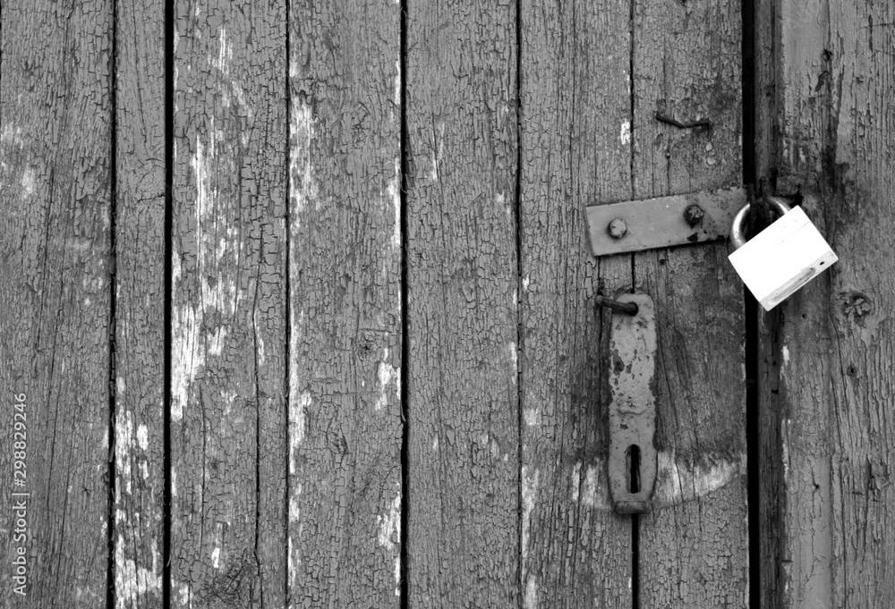 Grungy wooden door with lock in black and white.