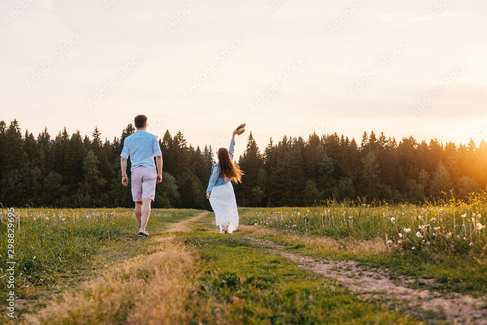 Running loving couple in the field. Sunset. Running loving couple in the field. Sunset.