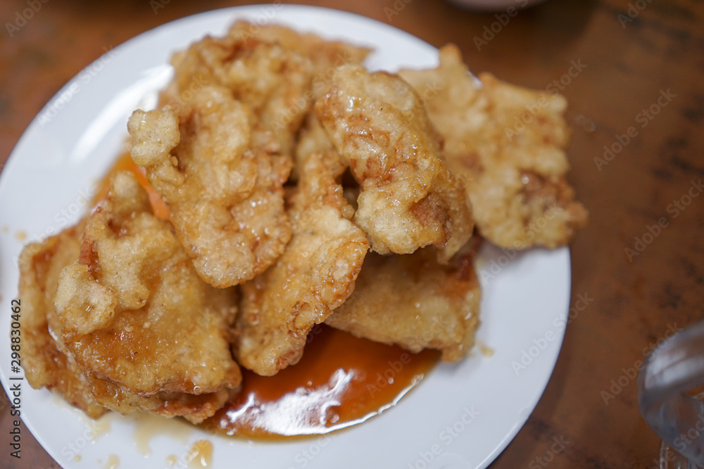 Gourmet fish and chips with chilli sauce on a white plate Gourmet fish and chips with chilli sauce on a white plate