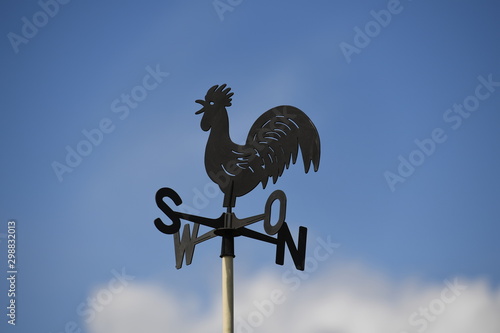 фотографія A weathercock in front of a blue sky.