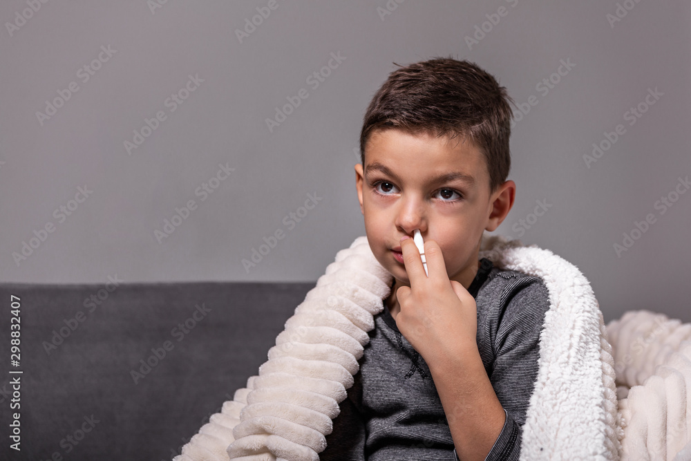 Kid is having flu and he is using nasal spray to help himself. Boy using nasal spray. Nasal
