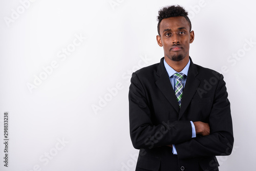 Young bearded African businessman wearing suit against white bac