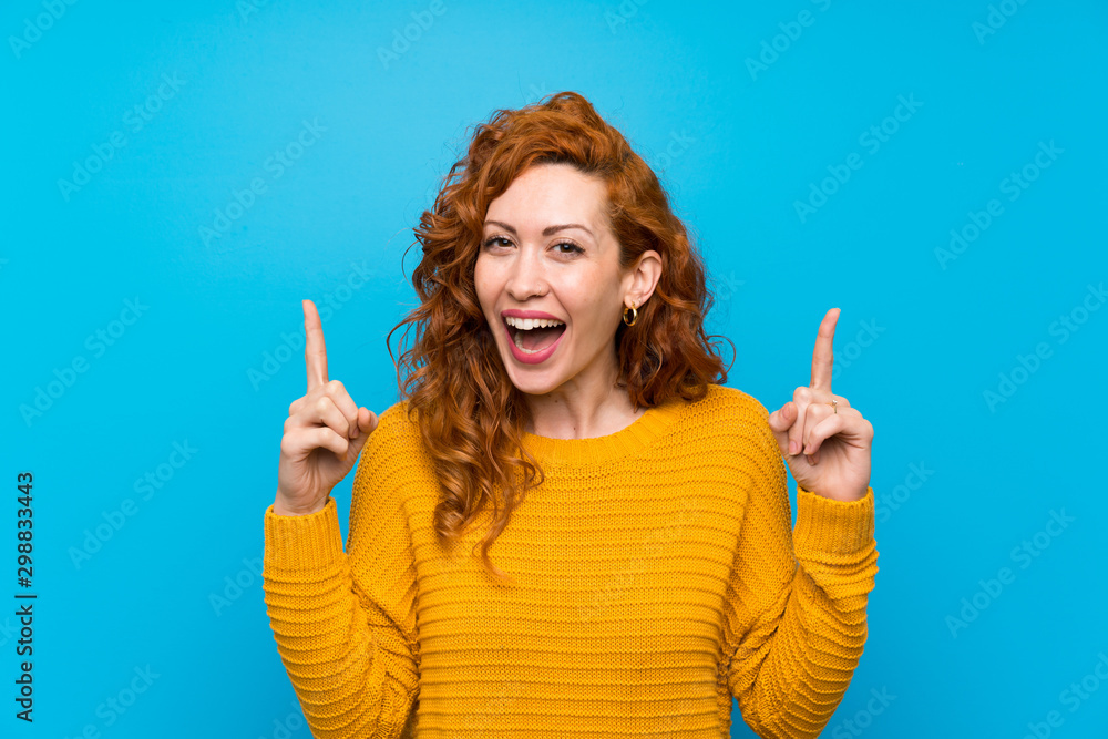Redhead woman with yellow sweater pointing up a great idea Redhead woman with yellow sweater pointing up a great idea