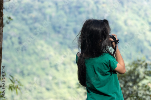 The girls go on a trip and take pictures of forests and mountains on a holiday.