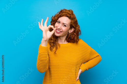 Принти на полотні Redhead woman with yellow sweater showing ok sign with fingers