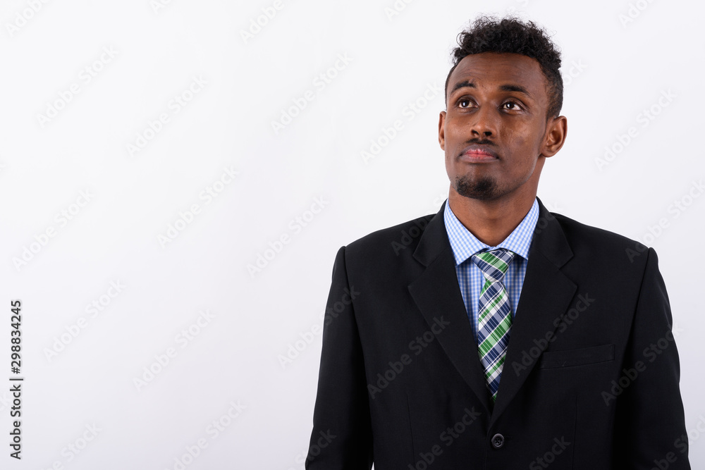 Young bearded African businessman wearing suit against white bac Young bearded African businessman wearing suit against white bac