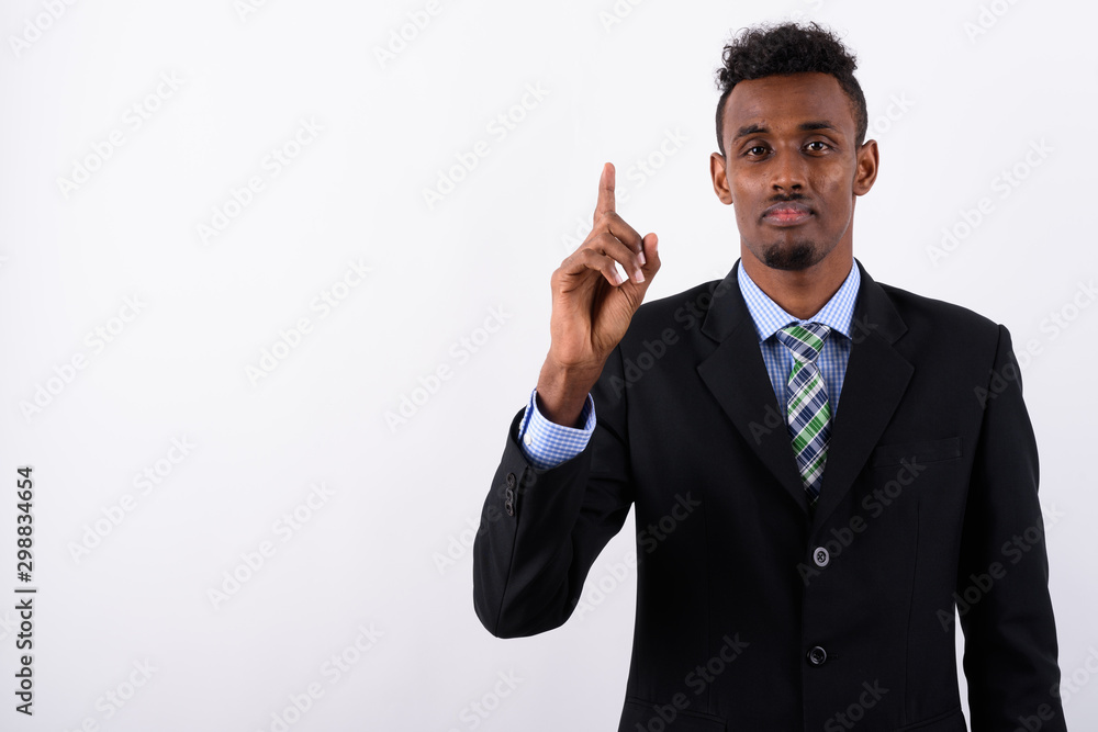 Young bearded African businessman wearing suit against white bac Young bearded African businessman wearing suit against white bac
