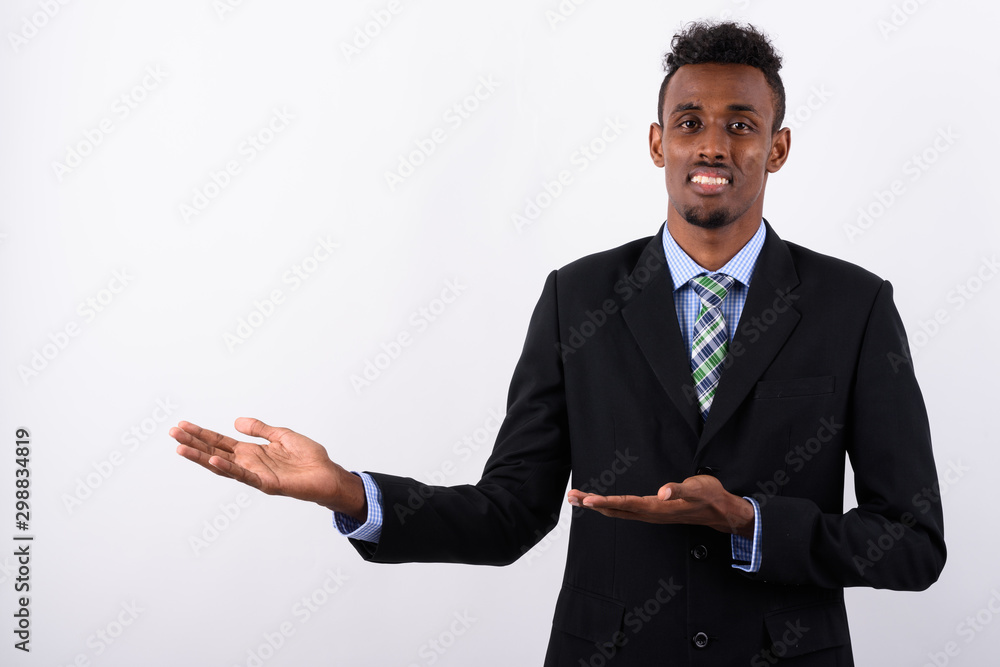 Young bearded African businessman wearing suit against white bac Young bearded African businessman wearing suit against white bac