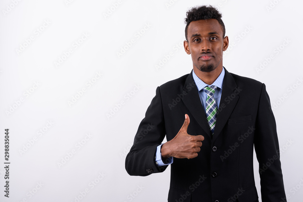 Young bearded African businessman wearing suit against white bac Young bearded African businessman wearing suit against white bac