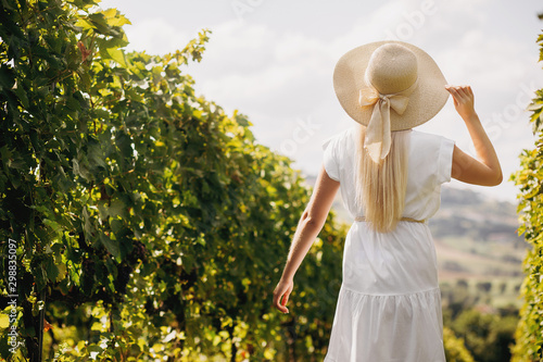Beautiful girl in hat walking on large vineyard plantation,Tuscany, Italy. © VAKSMANV