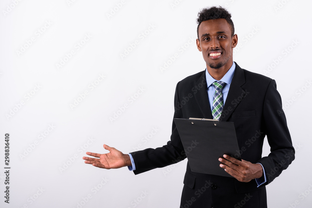 Young bearded African businessman wearing suit against white bac Young bearded African businessman wearing suit against white bac