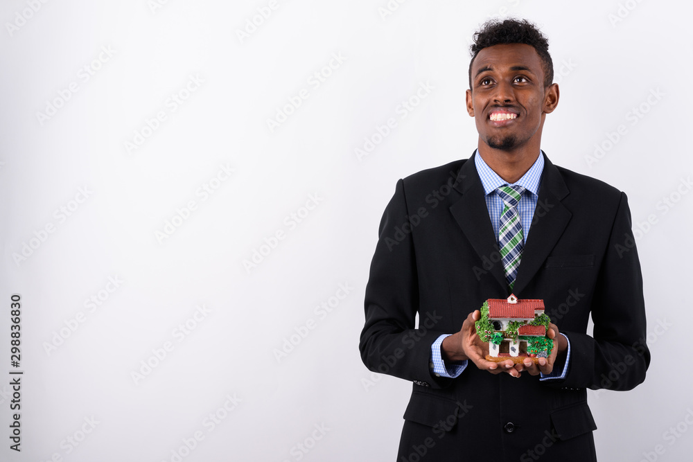 Young bearded African businessman wearing suit against white bac Young bearded African businessman wearing suit against white bac