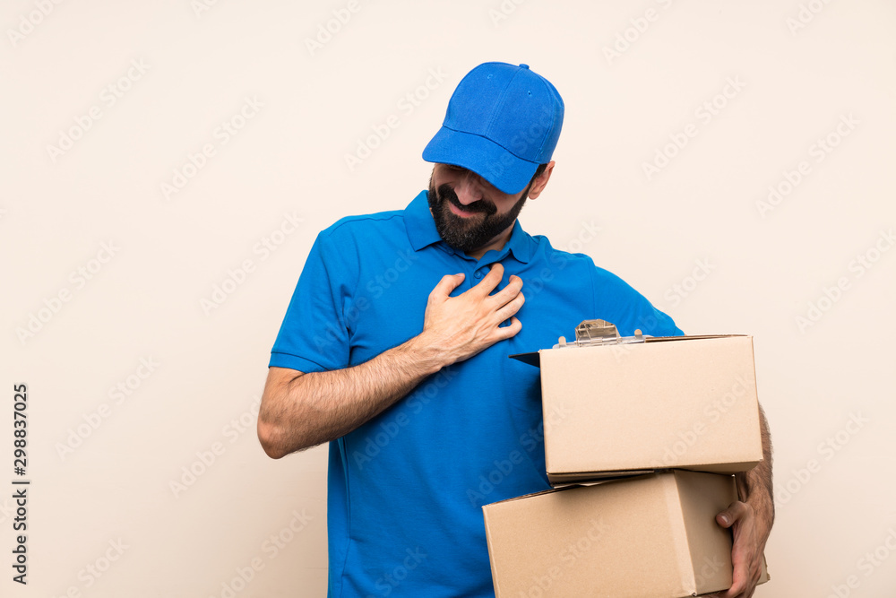 Delivery man with beard over isolated background having a pain in the heart Delivery man with beard over isolated background having a pain in the heart