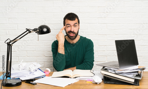 Student man making the gesture of madness putting finger on the head