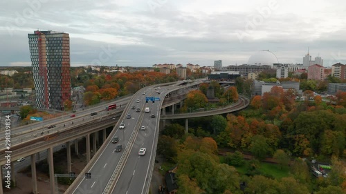 Drone flies backward over Stockholm traffic. Aerial view of Ericsson Globe, Sweden. photo