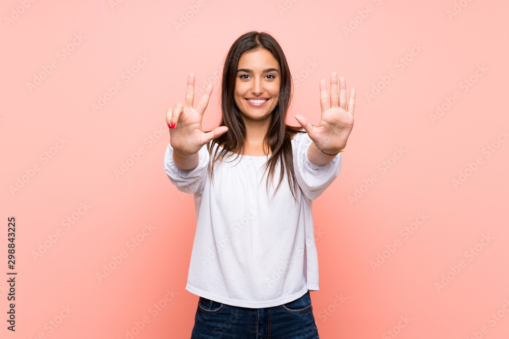 Young woman over isolated pink background counting eight with fingers Young woman over isolated pink background counting eight with fingers