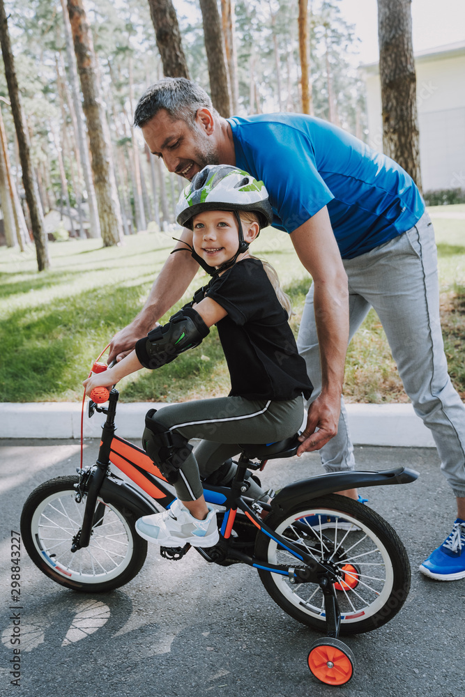 Obraz premium Father teaching his daughter to ride a bicycle