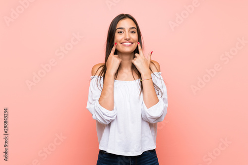 Young woman over isolated pink background smiling with a happy and pleasant expression