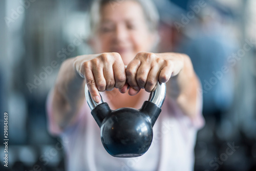 Foto close up of senior holding a weight with his hands in front of the camera at the