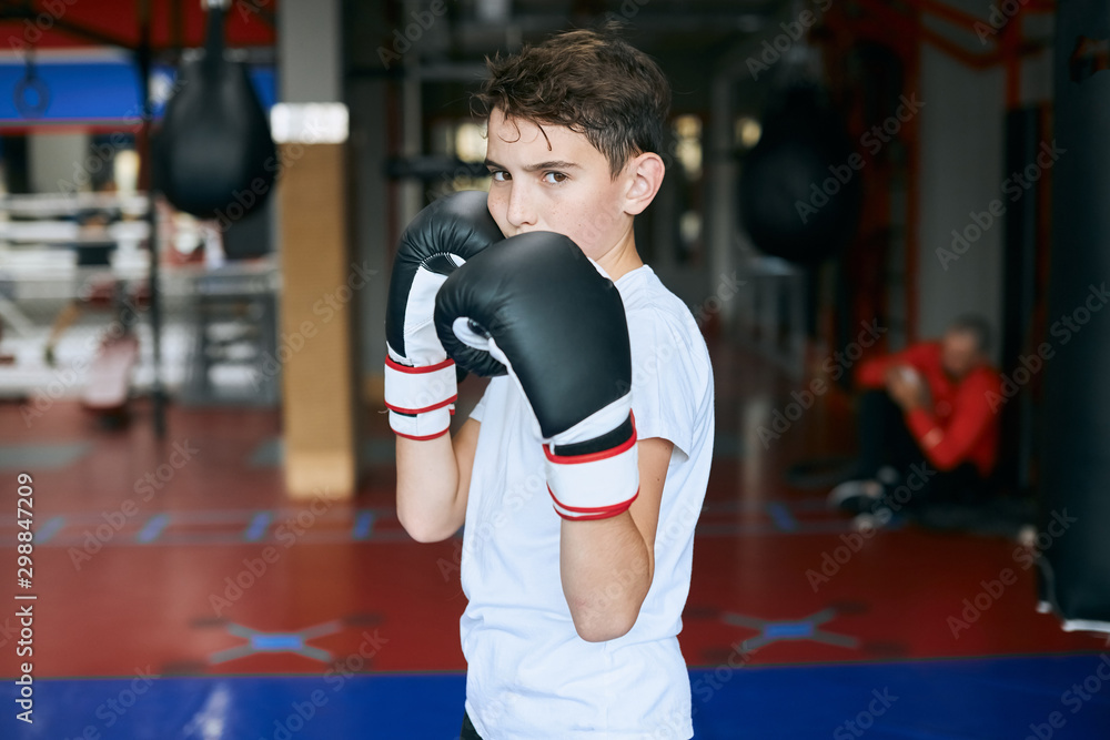 strong little boy standing in boxing positing, going to stike, close up photo