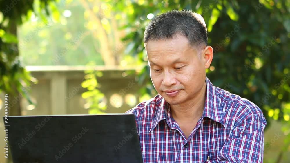 Man working with laptop in the garden, outdoor Chiangmai Thailand Man working with laptop in the garden, outdoor Chiangmai Thailand