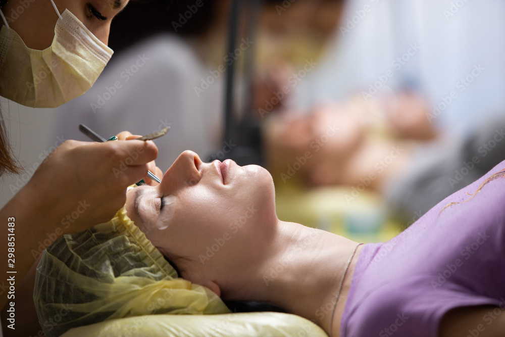 The master builds up large colored eyelashes to the client. Preparation for beauty photography. Creating an image. The master builds up large colored eyelashes to the client. Preparation for beauty photography. Creating an image.