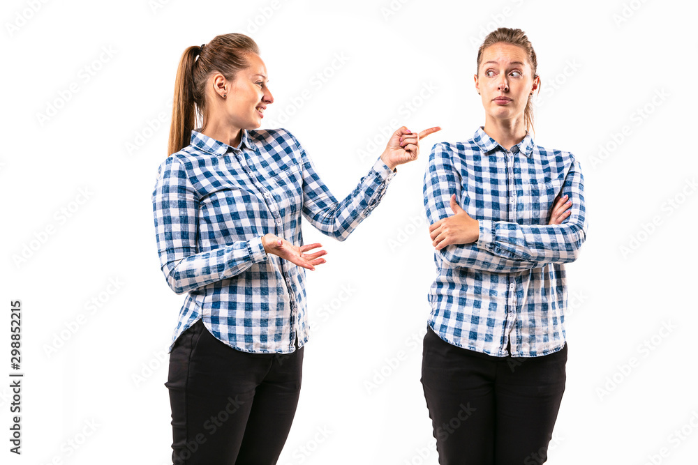 Young handsome woman arguing with herself on white studio background. Concept of human emotions, expression, mental issues, internal conflict, split personality. Half-length portrait. Negative space. Young handsome woman arguing with herself on white studio background. Concept of human emotions, expression, mental issues, internal conflict, split personality. Half-length portrait. Negative space.
