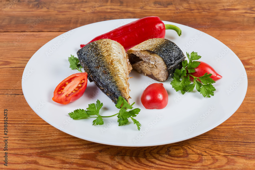 Baked mackerel slices, fresh vegetables, parsley on dish close-up Baked mackerel slices, fresh vegetables, parsley on dish close-up