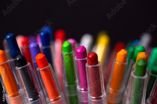 Bunch of random colored crayon pencils, close up macro. Black background
