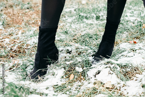black boots on the green grass in the snow