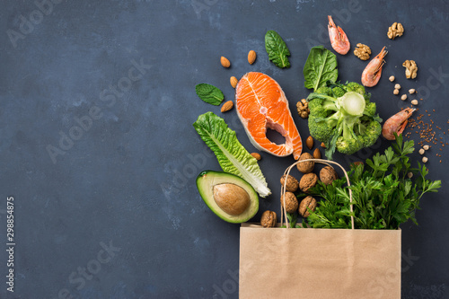 Shopping bag with healthy food on dark background with copy space top view